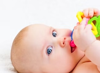 Baby playing with a colorful soother