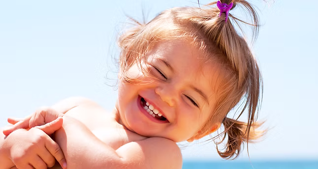 Parent holding a smiling baby